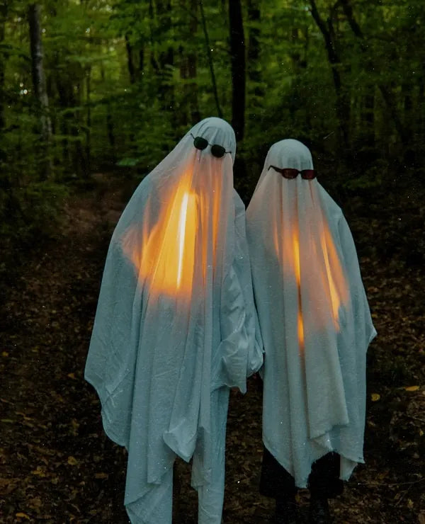 Two ghosts with lanterns in a dark forest